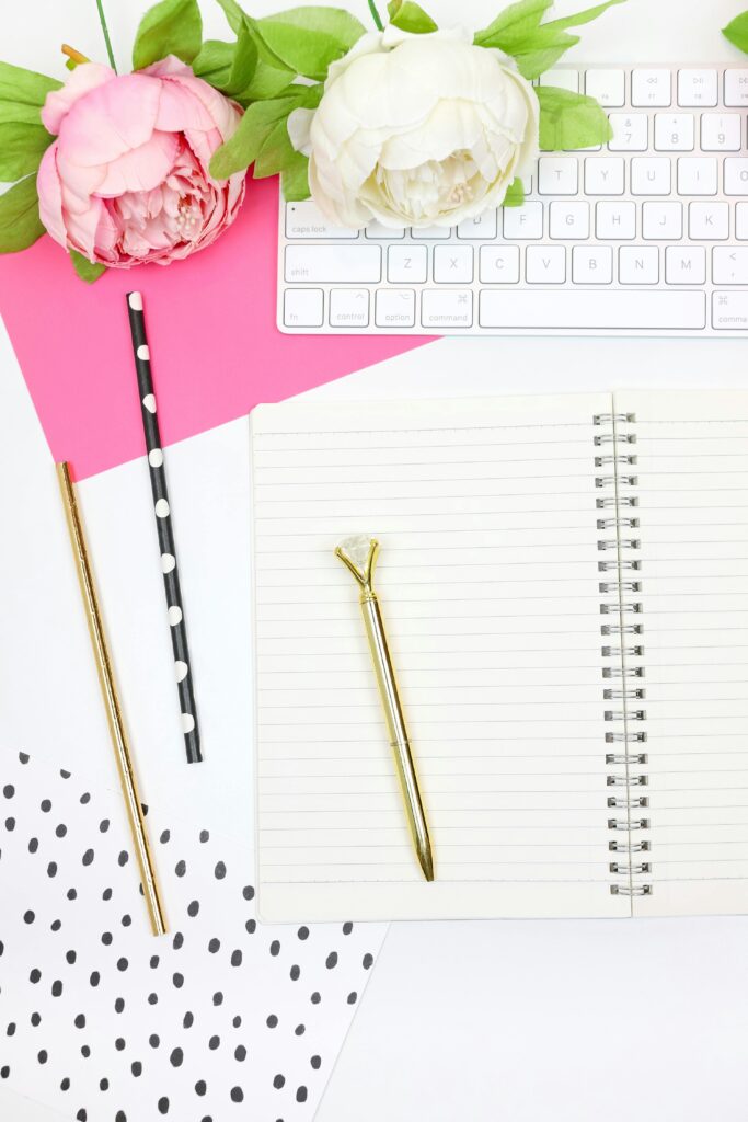 Bright and stylish workspace with notebook, flowers, and polka dot accents for an inspiring desk layout.